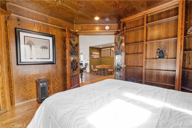 bedroom featuring wood walls, light hardwood / wood-style flooring, and wooden ceiling