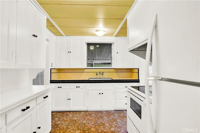 kitchen featuring decorative backsplash, sink, white cabinets, and white appliances