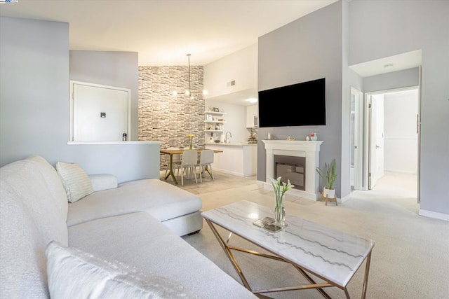 living room featuring high vaulted ceiling, a chandelier, light carpet, and sink