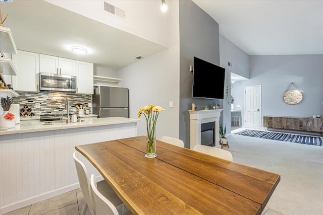 dining area featuring sink and lofted ceiling