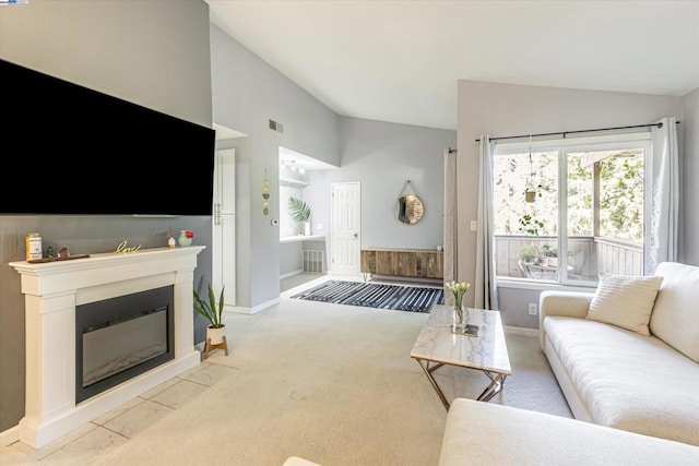 carpeted living room featuring vaulted ceiling