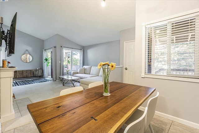 dining area with light tile patterned flooring and vaulted ceiling