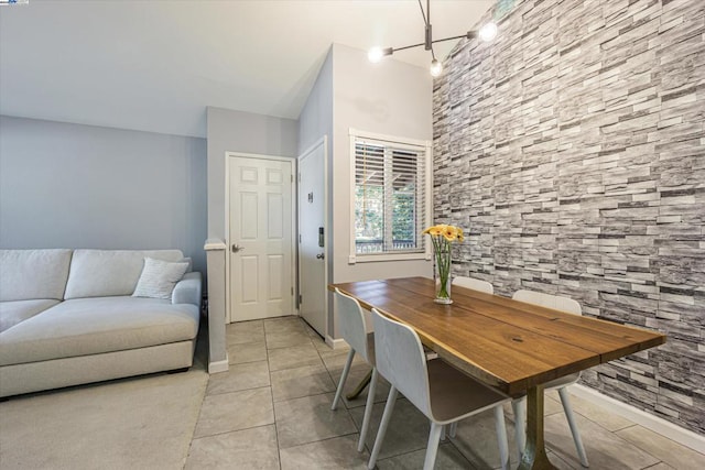 tiled dining space featuring a chandelier and rail lighting