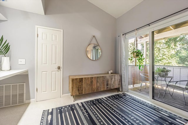 entryway featuring carpet flooring and vaulted ceiling