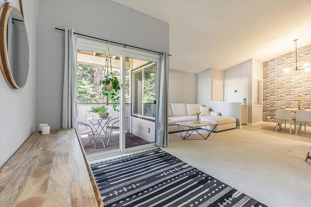 doorway to outside featuring vaulted ceiling and carpet