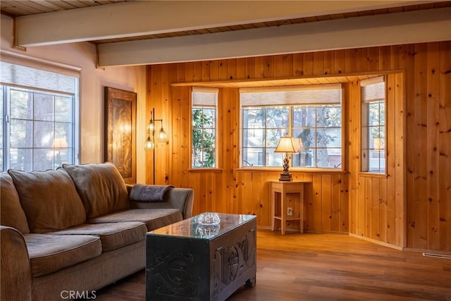 living room featuring wood ceiling, hardwood / wood-style flooring, wood walls, and beamed ceiling