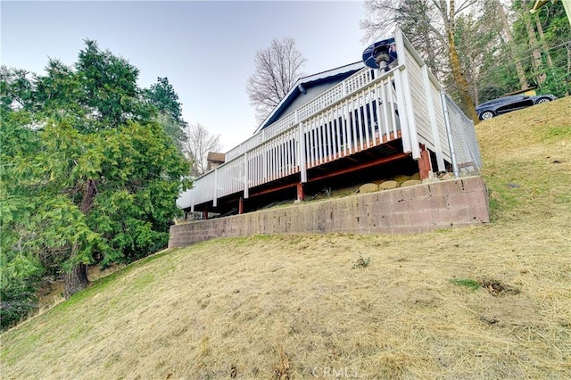 back of property with a deck and a lawn