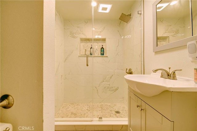 bathroom featuring vanity and a shower with door