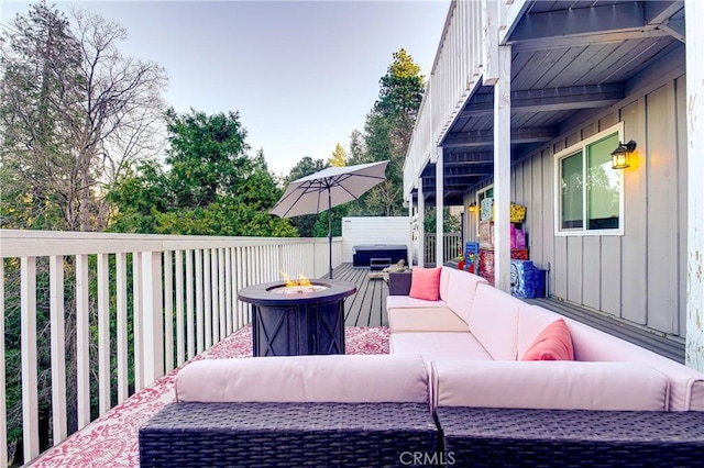 deck featuring an outdoor living space with a fire pit