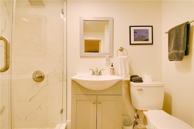 bathroom with an enclosed shower, vanity, and toilet