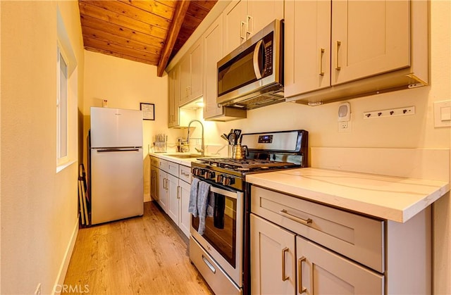 kitchen with wood ceiling, light hardwood / wood-style floors, stainless steel appliances, vaulted ceiling with beams, and light stone countertops