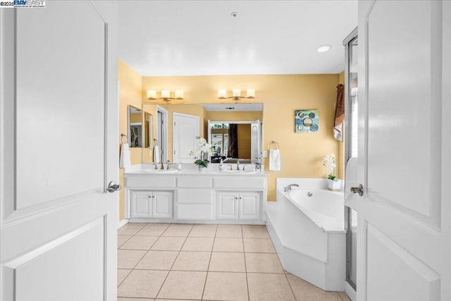 bathroom featuring vanity, tile patterned flooring, and a tub to relax in