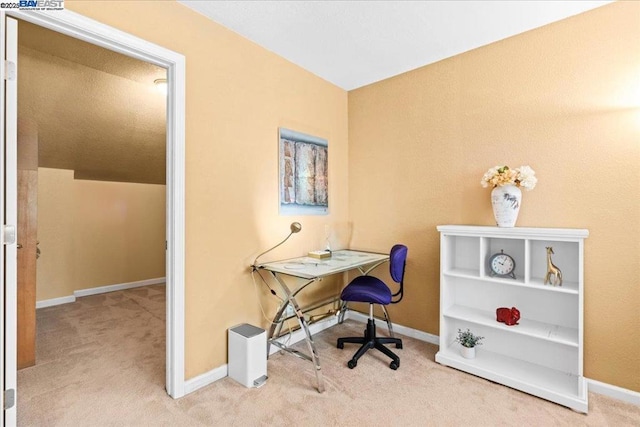 office area featuring lofted ceiling and light carpet