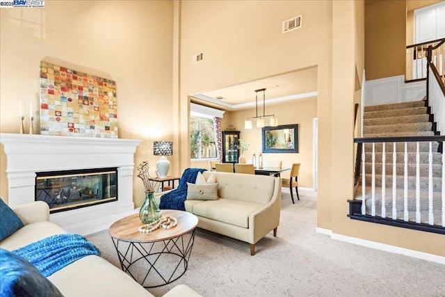 carpeted living room with a towering ceiling