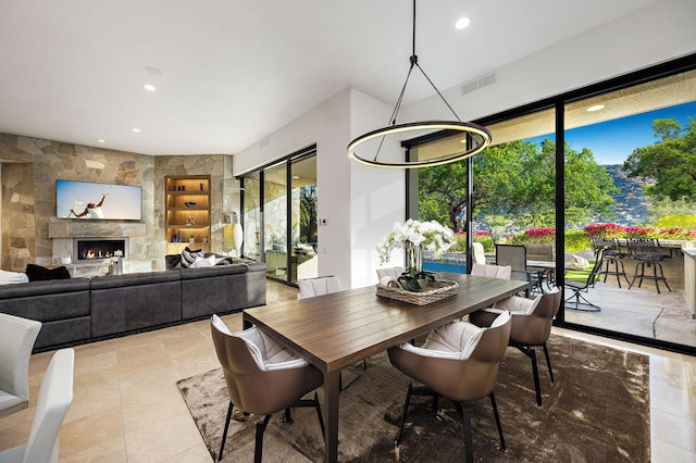 dining space featuring built in shelves and a large fireplace