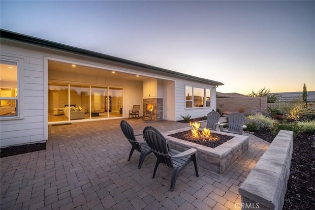 patio terrace at dusk featuring a fire pit