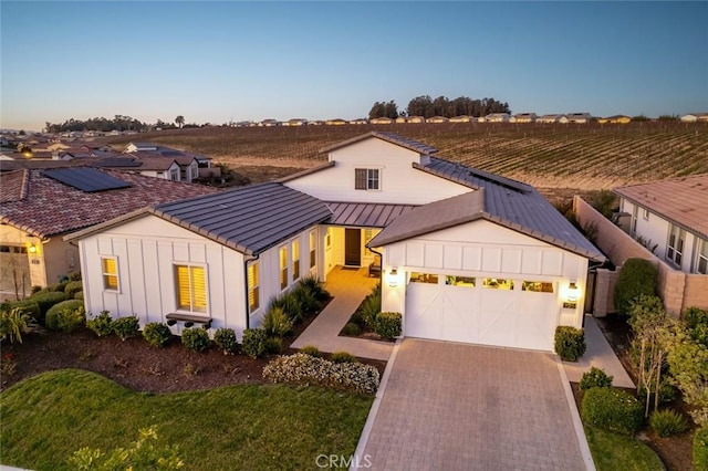 modern farmhouse with a rural view and a garage