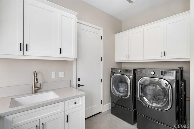 washroom featuring independent washer and dryer, cabinets, and sink