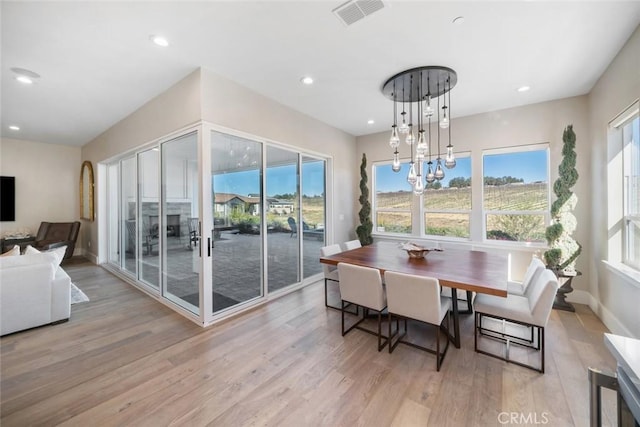 dining space featuring light hardwood / wood-style floors and a chandelier