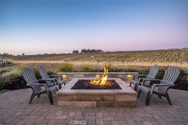 view of patio / terrace featuring an outdoor fire pit and a rural view