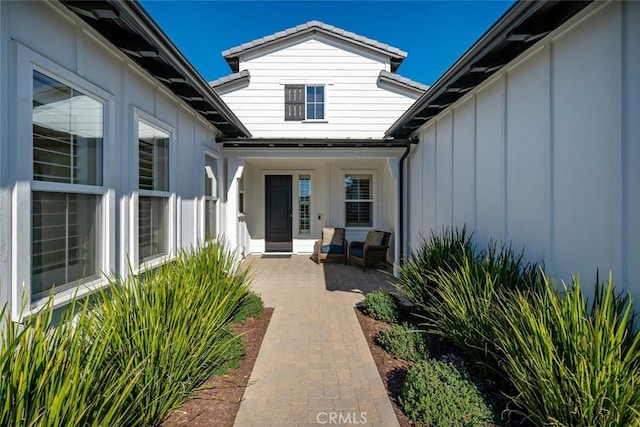 view of exterior entry featuring a patio area