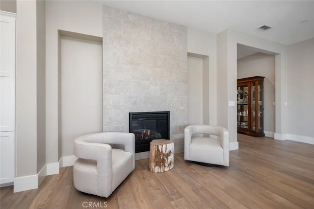 sitting room featuring a fireplace and light hardwood / wood-style floors