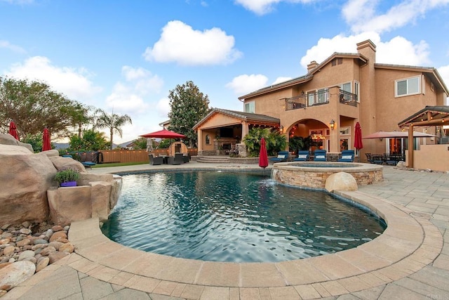 view of swimming pool with a gazebo, a patio area, pool water feature, and an in ground hot tub