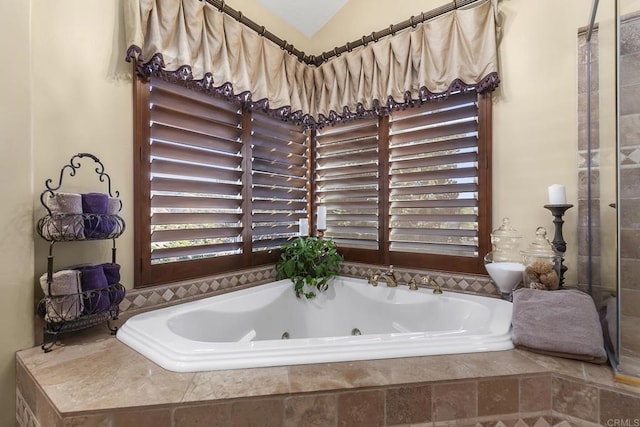 bathroom with lofted ceiling and tiled bath