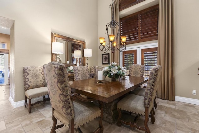 dining space with a high ceiling and an inviting chandelier