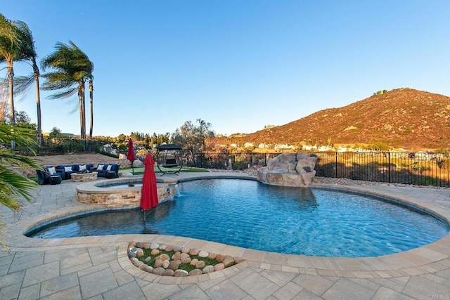 view of swimming pool featuring a patio, an in ground hot tub, pool water feature, and a mountain view