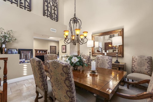 dining area with a towering ceiling and an inviting chandelier