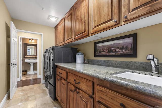 laundry area with washer and dryer, cabinets, sink, and light tile patterned floors