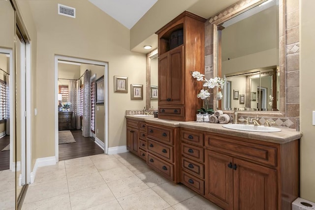 bathroom featuring lofted ceiling, tile patterned flooring, and vanity