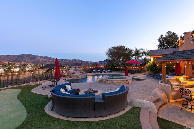 pool at dusk with an in ground hot tub, area for grilling, a mountain view, and a gazebo