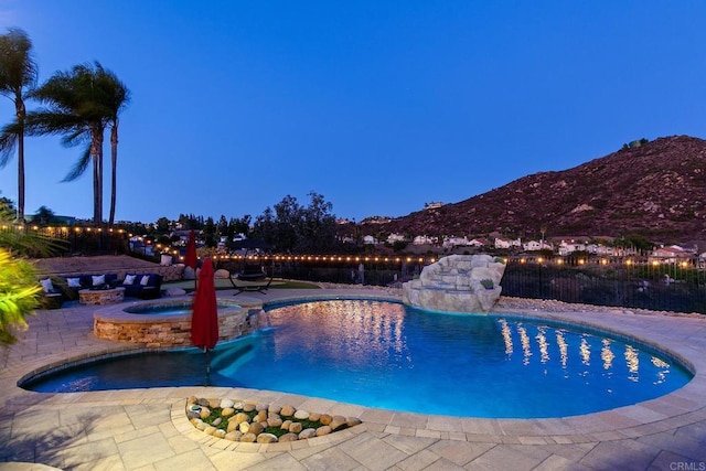 view of pool featuring a mountain view, a patio area, fence, and a pool with connected hot tub