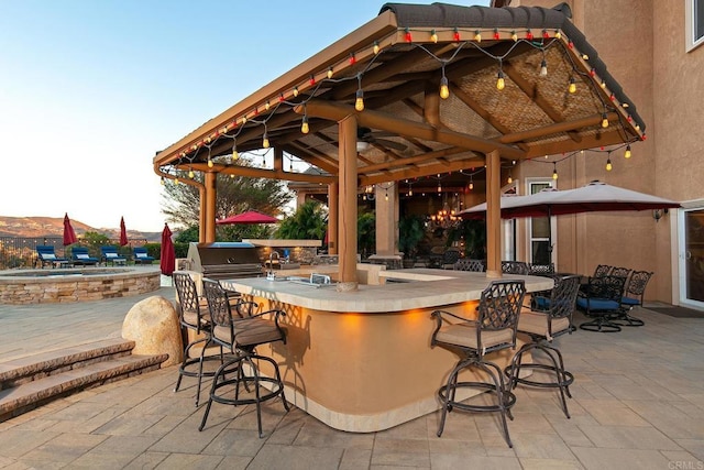 view of patio / terrace with a gazebo, a bar, and a grill