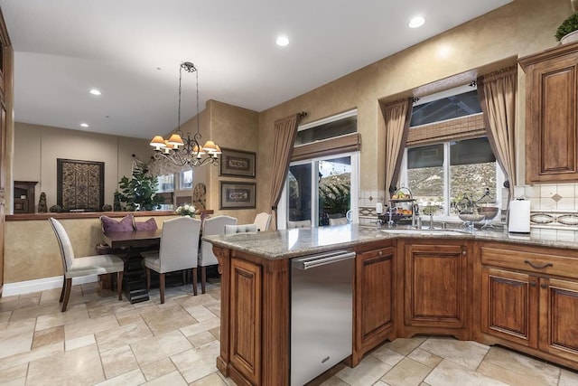 kitchen featuring stone countertops, brown cabinetry, and a sink