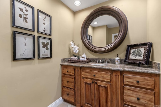 bathroom with vanity, recessed lighting, and baseboards