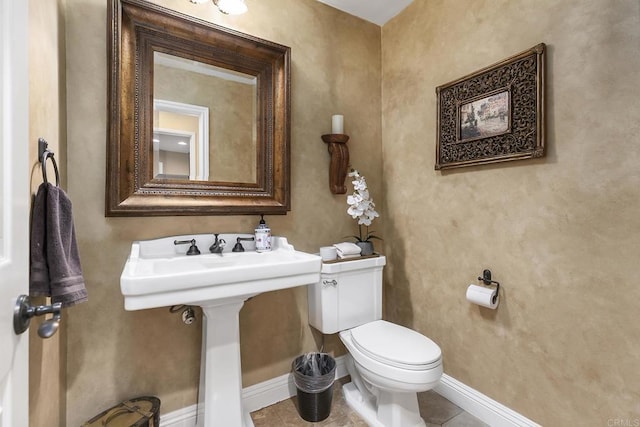 bathroom with tile patterned flooring, toilet, and baseboards