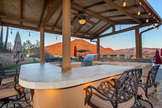 view of patio / terrace featuring a gazebo, a mountain view, a grill, and an outdoor kitchen