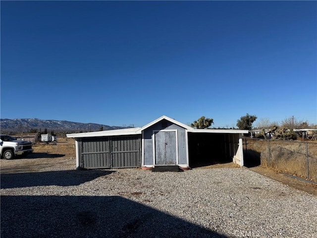 view of shed with fence and a mountain view
