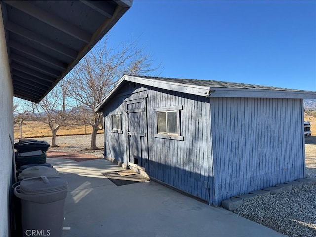 view of side of home featuring an outbuilding, a shed, and a patio