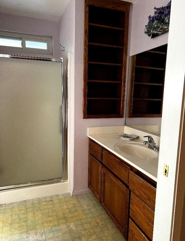 bathroom with a shower stall and vanity