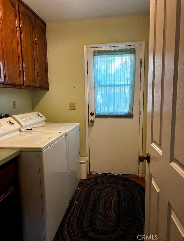 clothes washing area featuring cabinet space and independent washer and dryer