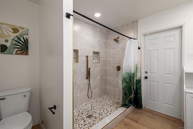 bathroom featuring toilet, walk in shower, and hardwood / wood-style floors