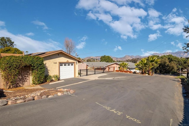 view of front facade with solar panels, a garage, and a mountain view