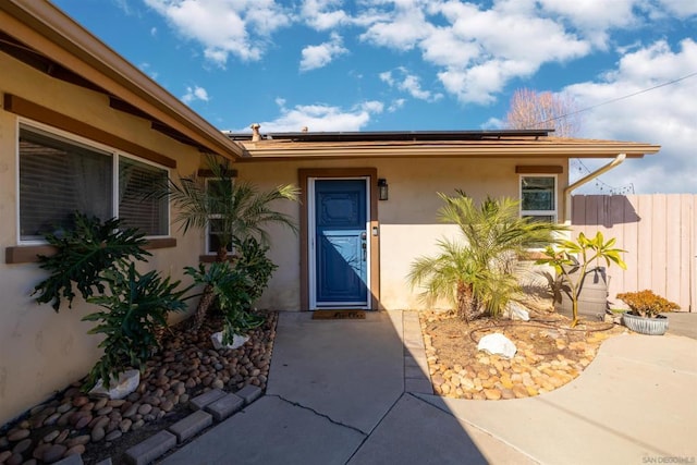 property entrance with solar panels and a patio area