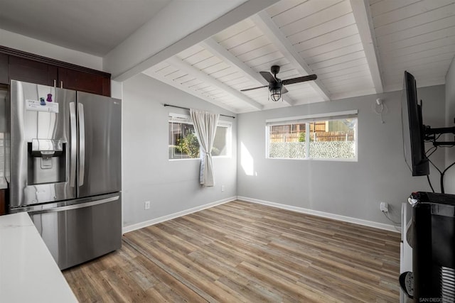 unfurnished living room featuring ceiling fan, lofted ceiling with beams, and hardwood / wood-style floors