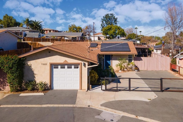 view of front of home featuring solar panels and a garage