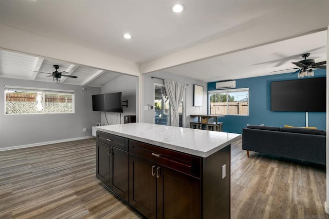 kitchen featuring wood-type flooring, a center island, lofted ceiling with beams, and ceiling fan